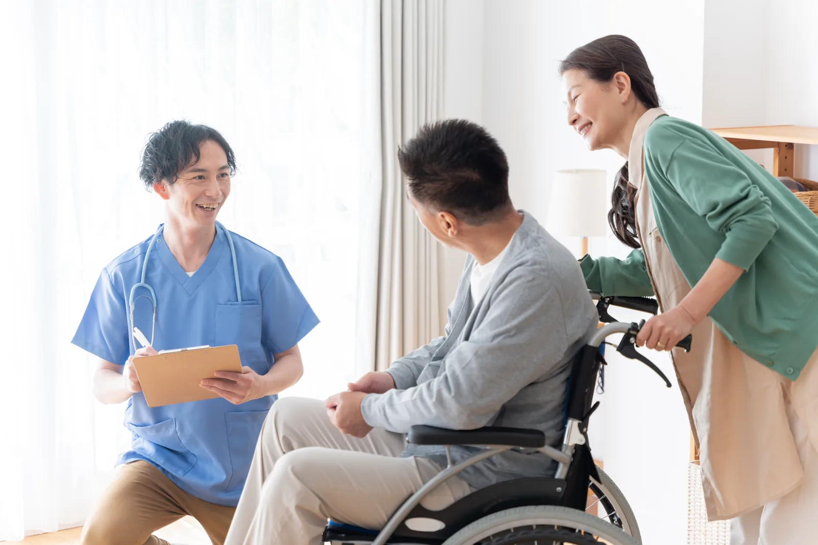 護理師在家中與輪椅上的長者及家屬討論返家照護安排
